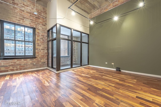 20 N State St Unit 1012, Chicago, IL 60602 - unfurnished room featuring a towering ceiling, hardwood / wood-style floors, and brick wall