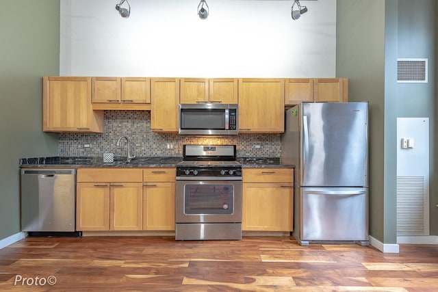 20 N State St Unit 1012, Chicago, IL 60602 - kitchen featuring appliances with stainless steel finishes, tasteful backsplash, light wood-style flooring, and dark stone countertops