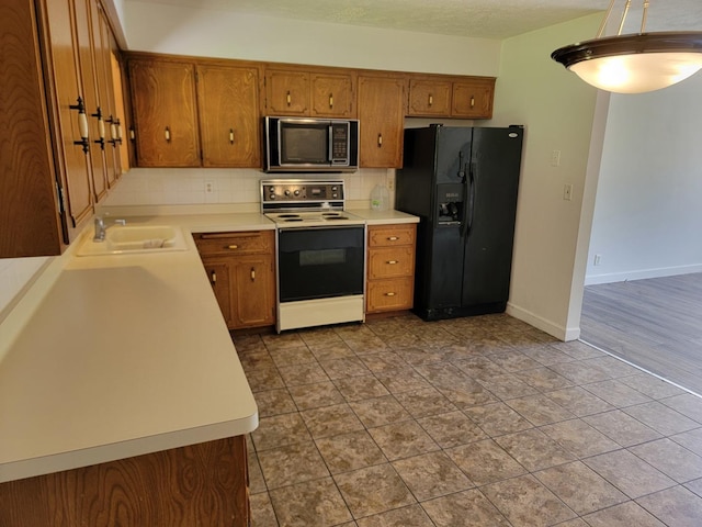 8788 Sheffield Dr, Belvidere, IL 61008 - kitchen with electric stove, black refrigerator with ice dispenser, brown cabinets, and decorative backsplash