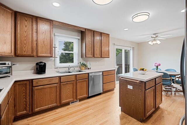 145 Barnes Rd, Elgin, IL 60124 - kitchen with stainless steel dishwasher, brown cabinetry, light wood-type flooring, a center island, and light countertops