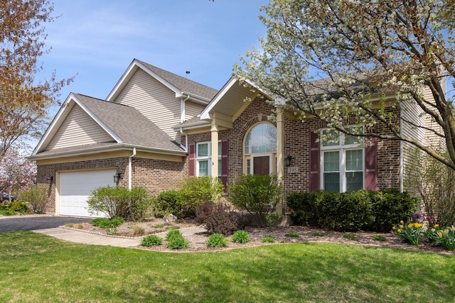 145 Barnes Rd, Elgin, IL 60124 - traditional home featuring brick siding, a garage, asphalt driveway, and a front yard