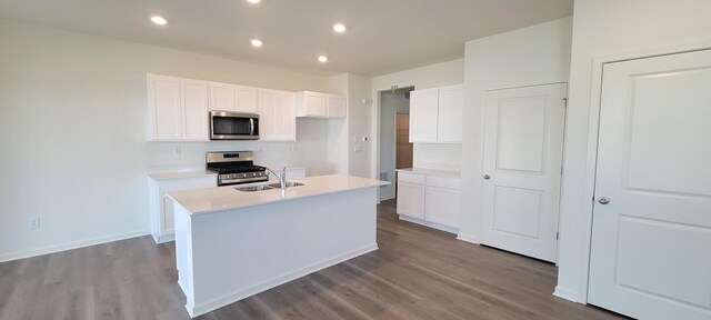 6455 Juniper Dr, Wonder Lake, IL 60097 - kitchen with stainless steel appliances, dark wood-style flooring, light countertops, white cabinetry, and an island with sink