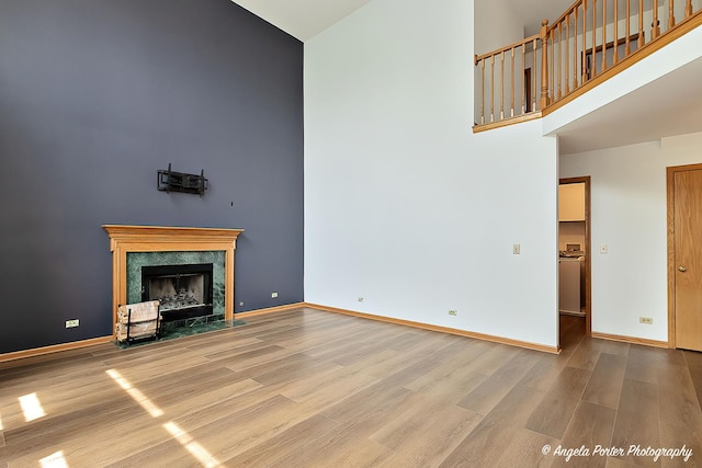 179 Cascade Dr, Crystal Lake, IL 60012 - unfurnished living room featuring a towering ceiling, wood finished floors, and a premium fireplace