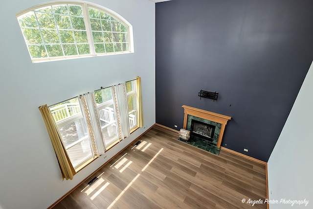 179 Cascade Dr, Crystal Lake, IL 60012 - unfurnished living room with a fireplace, wood finished floors, and a towering ceiling
