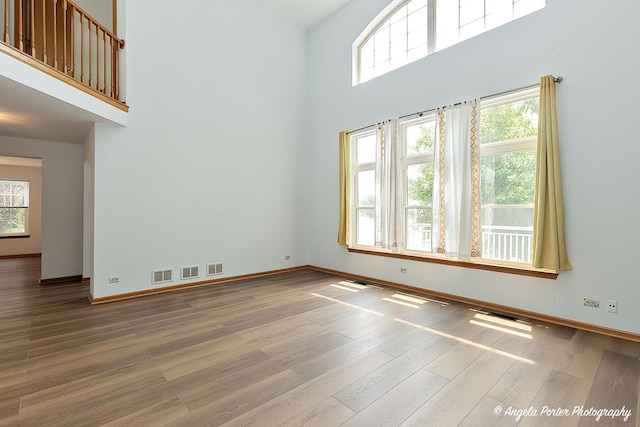 179 Cascade Dr, Crystal Lake, IL 60012 - unfurnished room featuring a towering ceiling, healthy amount of natural light, and wood finished floors