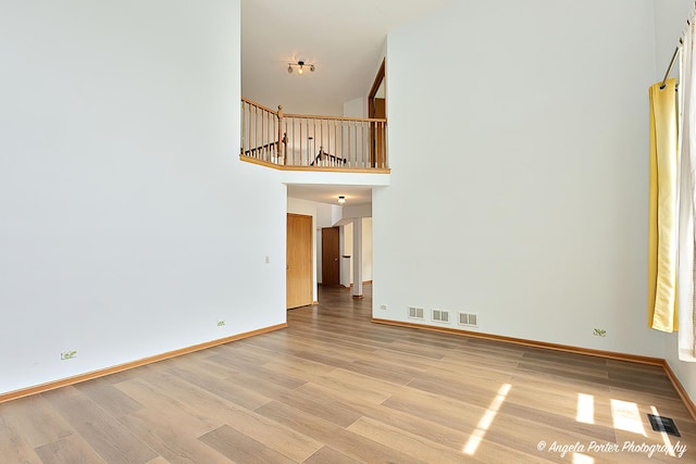 179 Cascade Dr, Crystal Lake, IL 60012 - unfurnished living room featuring light wood finished floors and a towering ceiling