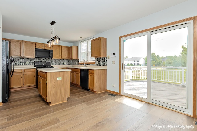 179 Cascade Dr, Crystal Lake, IL 60012 - kitchen with black appliances, light countertops, light wood-type flooring, tasteful backsplash, and hanging light fixtures