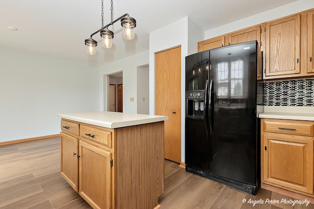 179 Cascade Dr, Crystal Lake, IL 60012 - kitchen featuring black fridge, tasteful backsplash, light wood-style floors, light countertops, and a center island