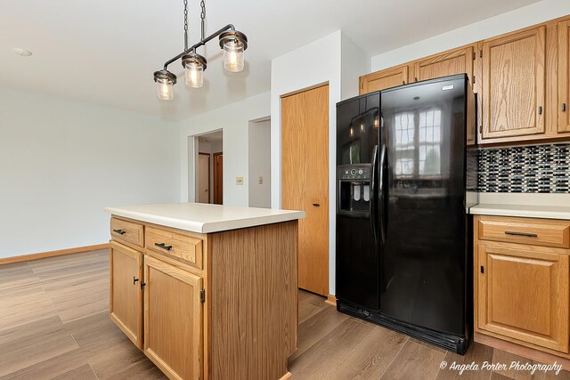 179 Cascade Dr, Crystal Lake, IL 60012 - kitchen featuring black refrigerator with ice dispenser, backsplash, light wood-type flooring, light countertops, and a kitchen island