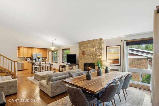 115 S We Go Trl, Mount Prospect, IL 60056 - dining area with a fireplace, light wood-style flooring, stairway, and vaulted ceiling