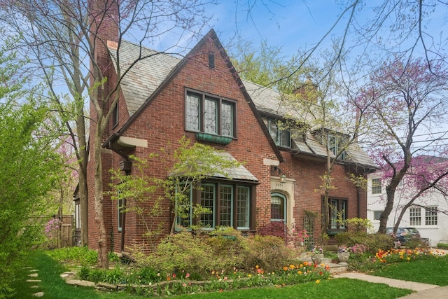 2951 Colfax St, Evanston, IL 60201 - tudor house with a chimney, a high end roof, and a front yard