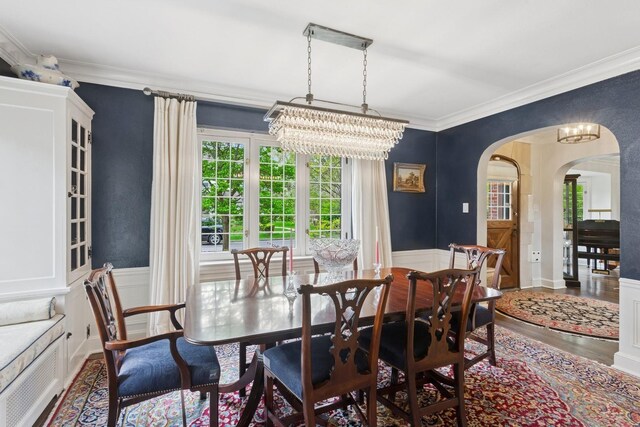 2951 Colfax St, Evanston, IL 60201 - dining room with arched walkways, a chandelier, wood finished floors, ornamental molding, and wainscoting