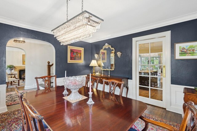 2951 Colfax St, Evanston, IL 60201 - dining area with arched walkways, wood finished floors, ornamental molding, a wainscoted wall, and a chandelier