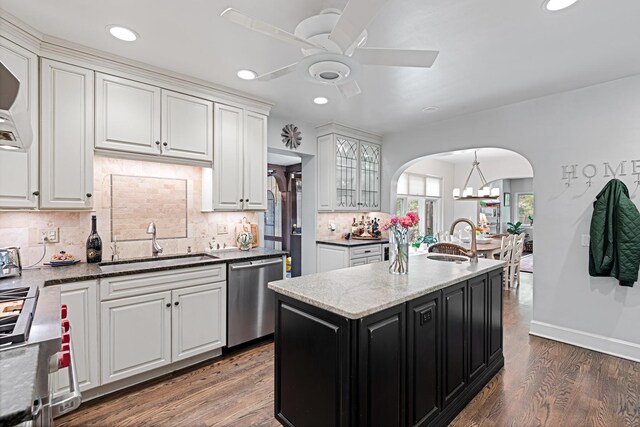 2951 Colfax St, Evanston, IL 60201 - kitchen with stainless steel dishwasher, a sink, arched walkways, a ceiling fan, and white cabinetry