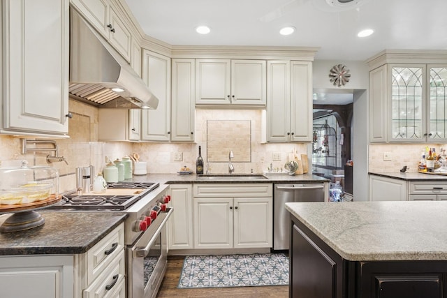 2951 Colfax St, Evanston, IL 60201 - kitchen with under cabinet range hood, stainless steel appliances, a sink, dark stone counters, and backsplash