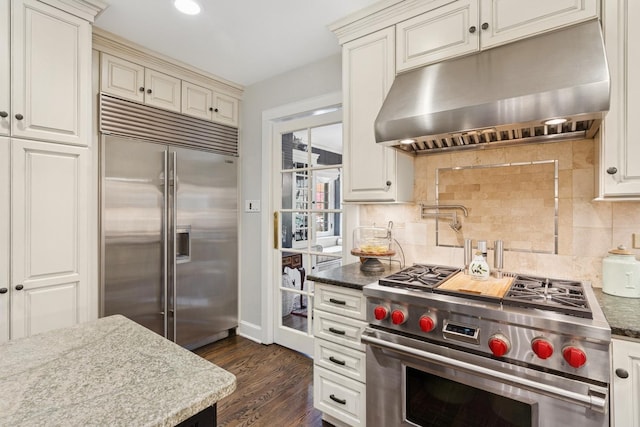 2951 Colfax St, Evanston, IL 60201 - kitchen with high quality appliances, under cabinet range hood, decorative backsplash, dark wood-style floors, and recessed lighting