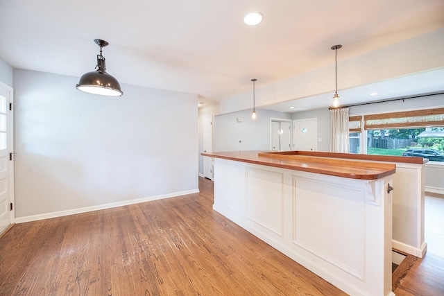 308 Dunbar Rd, Mundelein, IL 60060 - kitchen with wood counters, light wood-style floors, white cabinets, a kitchen island, and pendant lighting