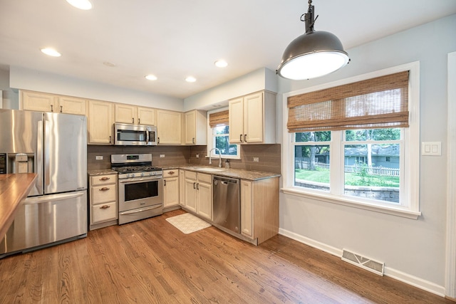 308 Dunbar Rd, Mundelein, IL 60060 - kitchen featuring appliances with stainless steel finishes, decorative backsplash, light wood-type flooring, recessed lighting, and hanging light fixtures