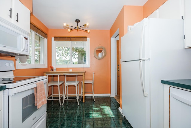 103 N Adelaide St, Normal, IL 61761 - kitchen with white appliances, white cabinetry, and a chandelier