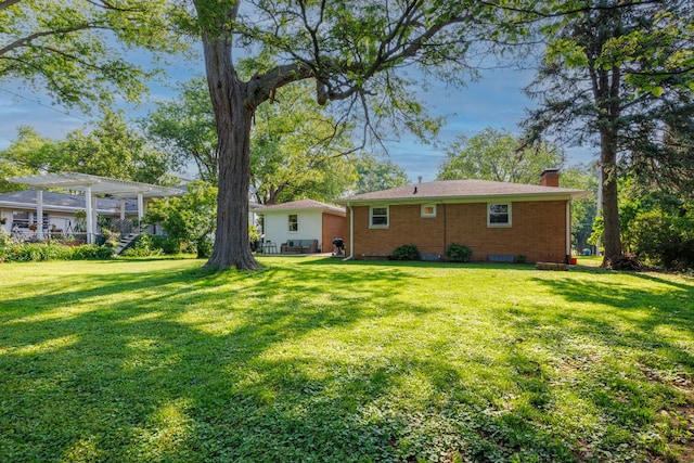 103 N Adelaide St, Normal, IL 61761 - rear view of property featuring a chimney, a yard, and brick siding