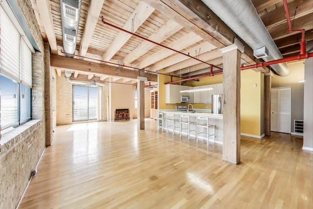 7240 Franklin St Unit 2A, Forest Park, IL 60130 - unfurnished living room with light wood-style flooring, ceiling fan, and ornate columns