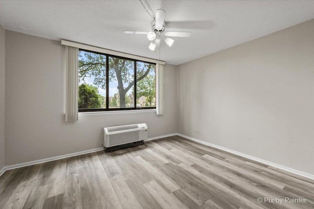 2000 Saint Regis Dr Unit 1D, Lombard, IL 60148 - unfurnished room featuring a wall mounted AC, wood finished floors, and ceiling fan