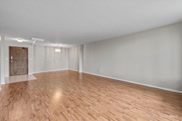 2000 Saint Regis Dr Unit 1D, Lombard, IL 60148 - unfurnished room with a chandelier, light wood finished floors, and a textured ceiling