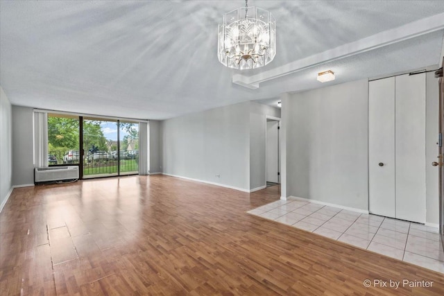 2000 Saint Regis Dr Unit 1D, Lombard, IL 60148 - unfurnished living room featuring floor to ceiling windows, a chandelier, and wood finished floors