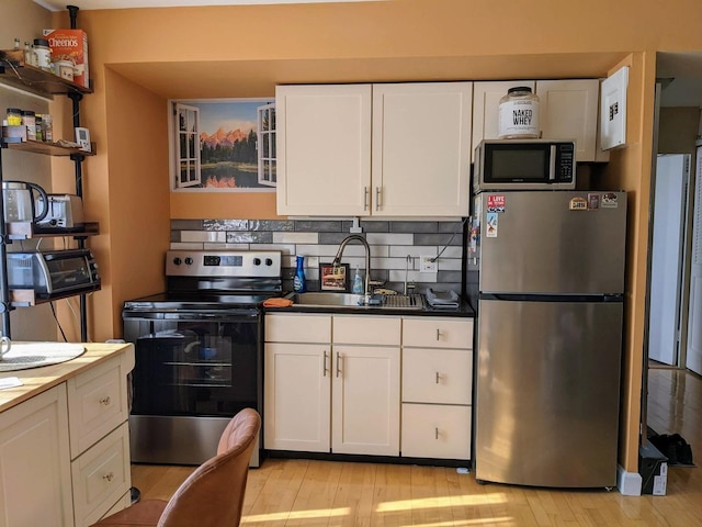 4950 N Marine Dr Unit 1105, Chicago, IL 60640 - kitchen featuring appliances with stainless steel finishes, light wood-type flooring, white cabinetry, tasteful backsplash, and open shelves