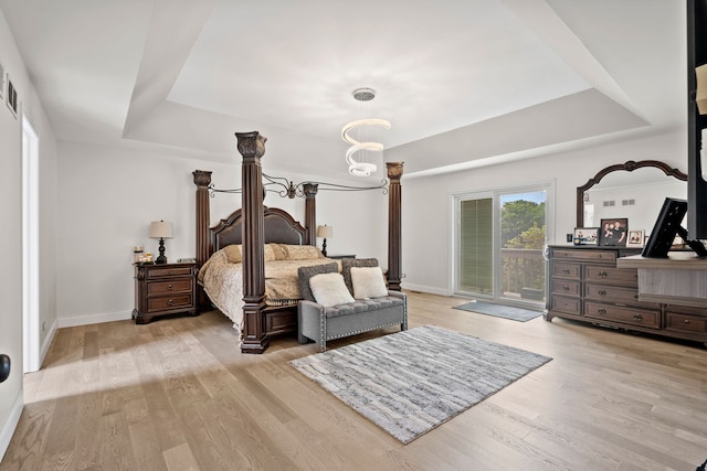 1542 Woodcreek Trl, Bartlett, IL 60103 - bedroom with a tray ceiling, access to outside, light wood-style floors, and a chandelier