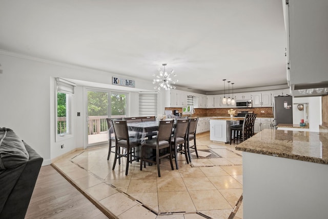 1542 Woodcreek Trl, Bartlett, IL 60103 - dining area featuring inlaid floor details, a chandelier, ornamental molding, and light tile patterned flooring