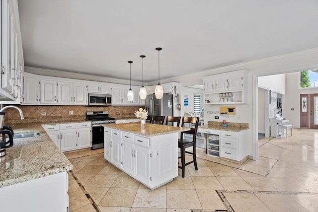 1542 Woodcreek Trl, Bartlett, IL 60103 - kitchen with stainless steel appliances, inlaid floor details, open shelves, crown molding, and white cabinets