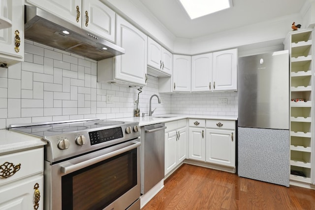 1105 N Mill St Unit 215, Naperville, IL 60563 - kitchen featuring appliances with stainless steel finishes, under cabinet range hood, wood finished floors, light countertops, and tasteful backsplash