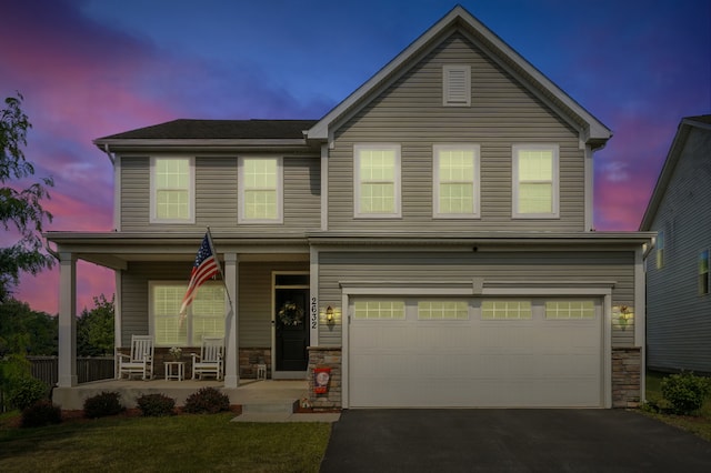 2632 Pecos Cir, Montgomery, IL 60538 - traditional-style house with a porch, an attached garage, driveway, and stone siding