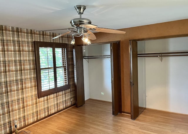 3485 Ronald Rd, Crete, IL 60417 - unfurnished bedroom featuring multiple closets, light wood-type flooring, and ceiling fan