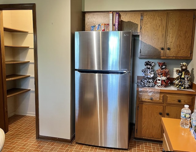 3485 Ronald Rd, Crete, IL 60417 - kitchen with freestanding refrigerator, brick patterned floors, brown cabinetry, and light countertops