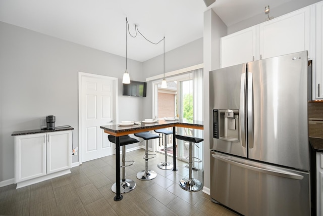 2208 W Concord Ln, Addison, IL 60101 - kitchen with stainless steel refrigerator with ice dispenser, white cabinets, decorative light fixtures, and dark stone countertops