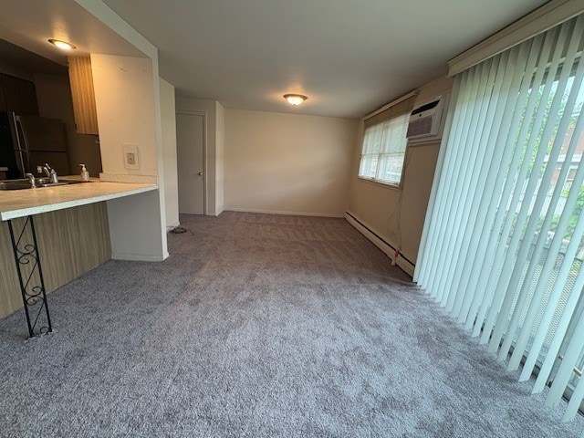 8801 Robin Dr Unit C, Des Plaines, IL 60016 - unfurnished living room with a baseboard radiator, carpet flooring, and an AC wall unit