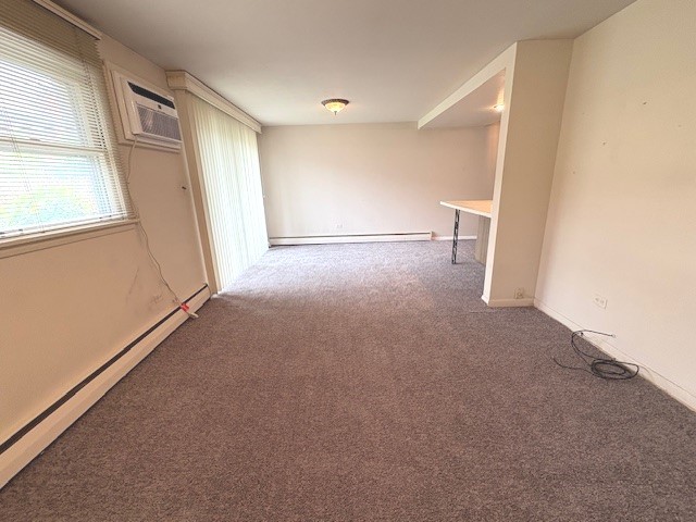 8801 Robin Dr Unit C, Des Plaines, IL 60016 - unfurnished room with baseboard heating, carpet, and a wall mounted AC