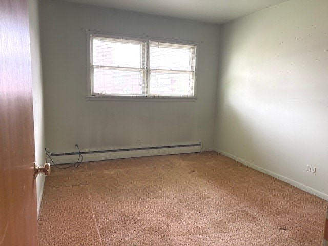 8801 Robin Dr Unit C, Des Plaines, IL 60016 - carpeted empty room with a baseboard heating unit and baseboards