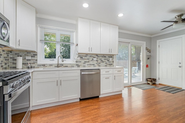 1910 Heather Ln, Joliet, IL 60431 - kitchen with stainless steel appliances, a ceiling fan, light wood-style floors, crown molding, and light countertops