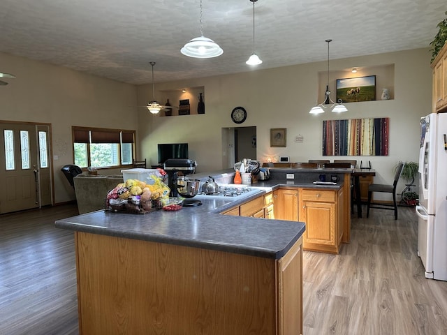 80 Smit Rd, Prophetstown, IL 61277 - kitchen with dark countertops, freestanding refrigerator, stainless steel gas stovetop, light wood-style floors, and a spacious island