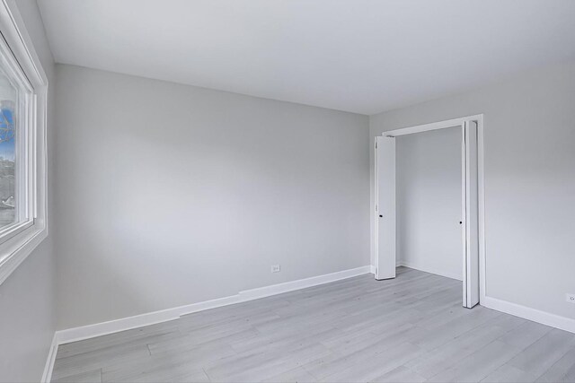 8433 W Betty Ter W, Niles, IL 60714 - empty room with light wood-style floors and baseboards
