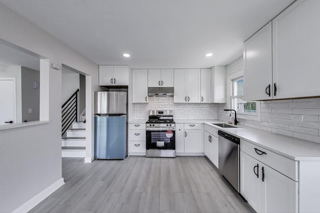 8433 W Betty Ter W, Niles, IL 60714 - kitchen with stainless steel appliances, under cabinet range hood, light countertops, tasteful backsplash, and white cabinets