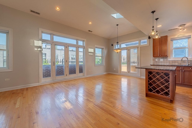3454 N Ashland Ave Unit 4S, Chicago, IL 60657 - kitchen with light wood finished floors, pendant lighting, decorative backsplash, brown cabinets, and recessed lighting
