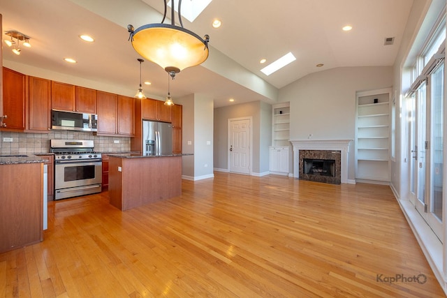 3454 N Ashland Ave Unit 4S, Chicago, IL 60657 - kitchen featuring appliances with stainless steel finishes, a skylight, light wood-type flooring, open floor plan, and a center island