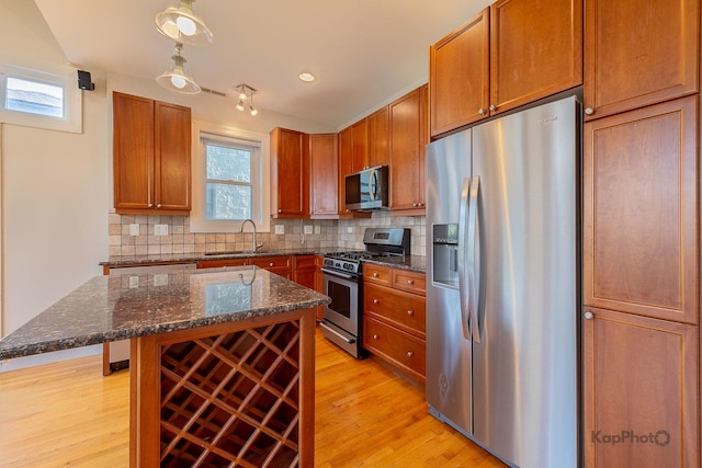 3454 N Ashland Ave Unit 4S, Chicago, IL 60657 - kitchen with stainless steel appliances, light wood-style floors, decorative backsplash, dark stone counters, and a center island