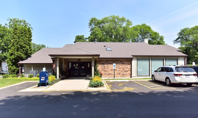 1400 N Elmhurst Rd Unit 310, Mount Prospect, IL 60056 - view of front of home featuring brick siding, uncovered parking, and a chimney