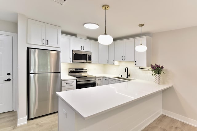 1400 N Elmhurst Rd Unit 310, Mount Prospect, IL 60056 - kitchen featuring stainless steel appliances, a peninsula, light wood-style floors, decorative backsplash, and light countertops
