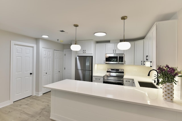 1400 N Elmhurst Rd Unit 310, Mount Prospect, IL 60056 - kitchen featuring appliances with stainless steel finishes, a peninsula, backsplash, light countertops, and light wood-style flooring